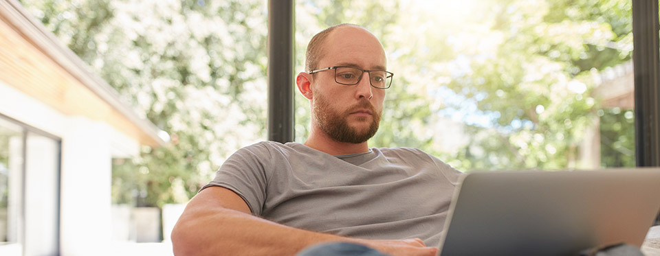 Image d'un jeune homme travaillant sur un PC